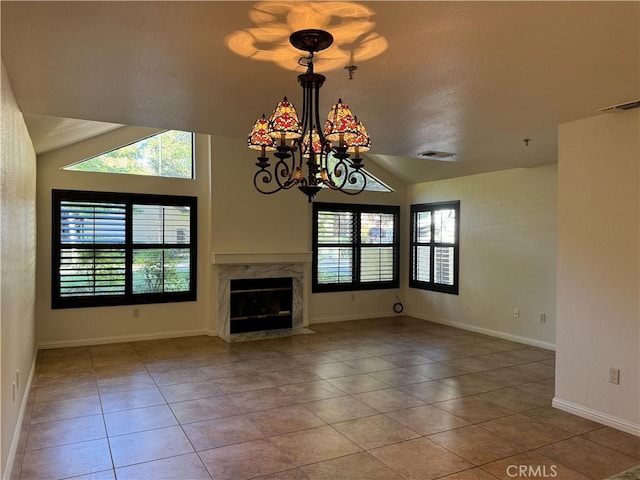 unfurnished living room featuring tile patterned floors, lofted ceiling, a premium fireplace, and a chandelier