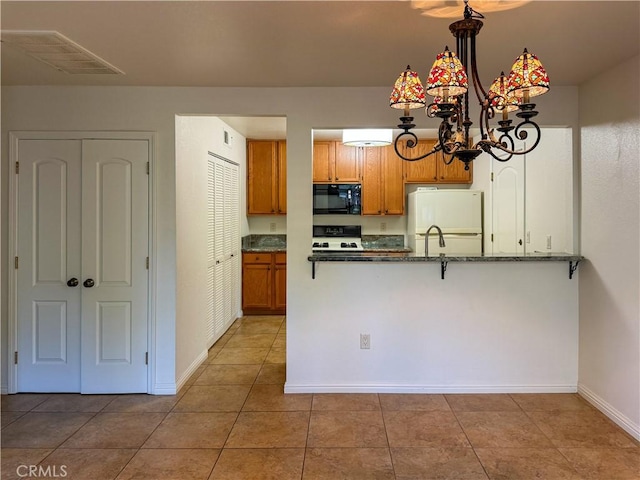 kitchen featuring light tile patterned flooring, a chandelier, white refrigerator, kitchen peninsula, and stove