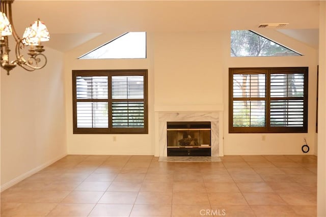 unfurnished living room with a chandelier, a fireplace, tile patterned flooring, and vaulted ceiling