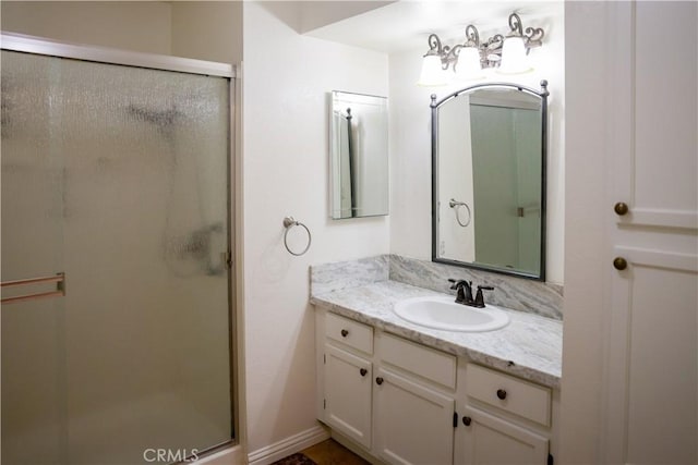 bathroom with a shower with door and vanity