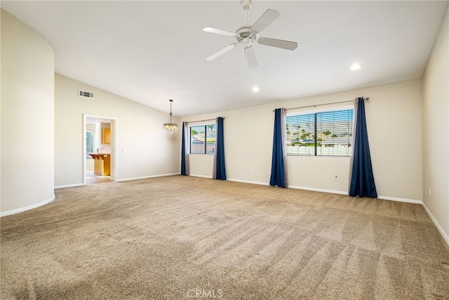 carpeted spare room featuring lofted ceiling and ceiling fan with notable chandelier