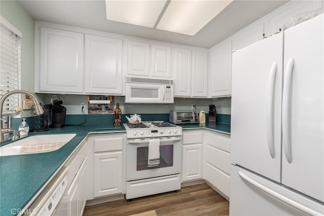 kitchen featuring hardwood / wood-style floors, sink, white appliances, and white cabinetry