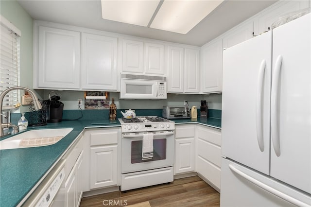 kitchen featuring a toaster, white appliances, wood finished floors, white cabinetry, and a sink