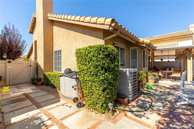 view of side of property with a patio and central air condition unit