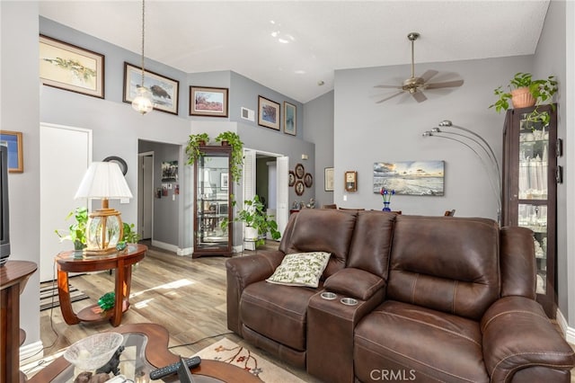 living room featuring high vaulted ceiling, light wood-type flooring, and ceiling fan