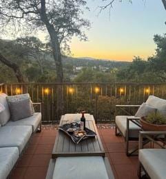 patio terrace at dusk featuring an outdoor living space