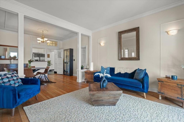 living room with a notable chandelier, crown molding, and hardwood / wood-style flooring