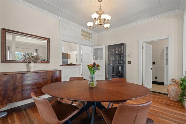 dining area featuring crown molding, a chandelier, and wood-type flooring