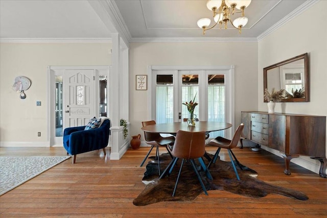 dining space with light hardwood / wood-style flooring, a chandelier, and crown molding