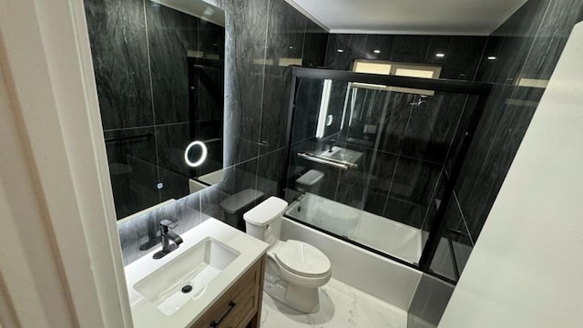 full bathroom featuring toilet, tile walls, vanity, and shower / bath combination with glass door