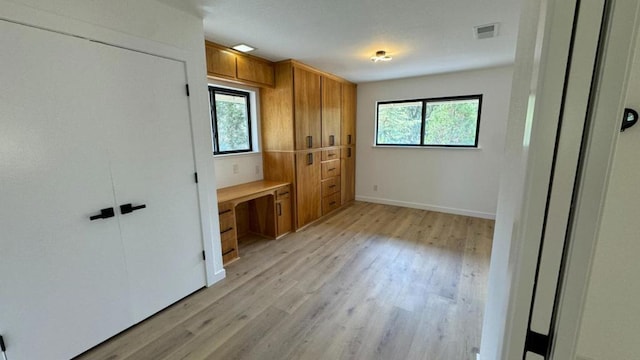 unfurnished bedroom featuring light hardwood / wood-style flooring and built in desk