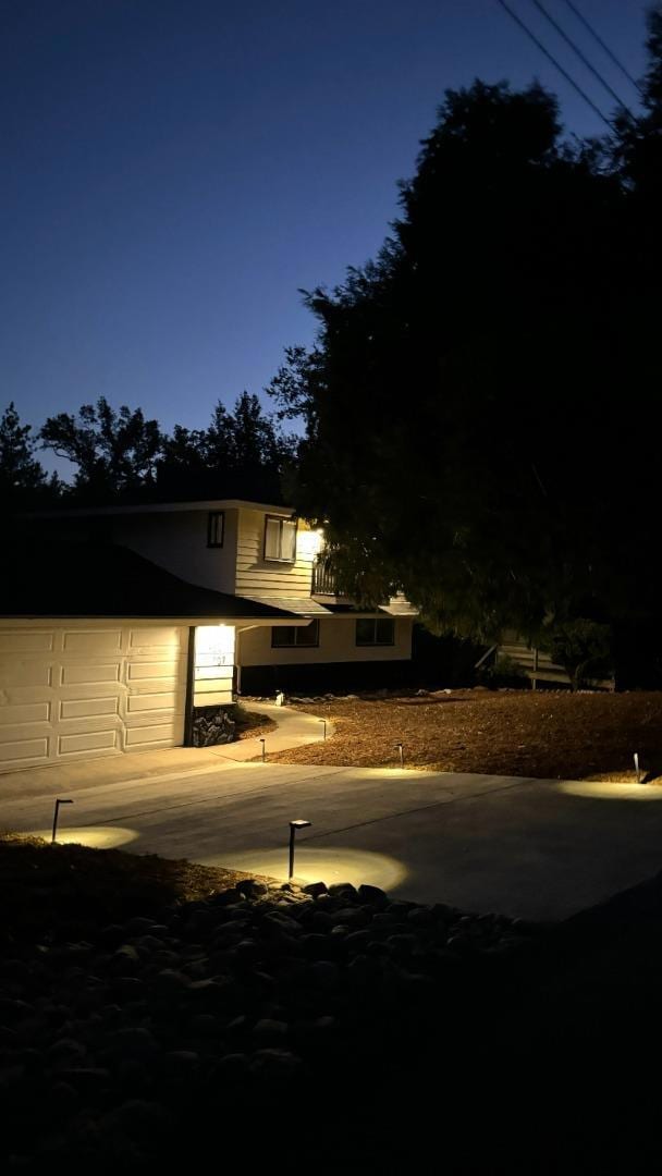 property exterior at night with a garage