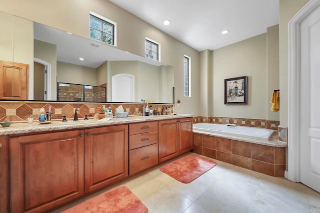 bathroom with vanity, separate shower and tub, and tasteful backsplash