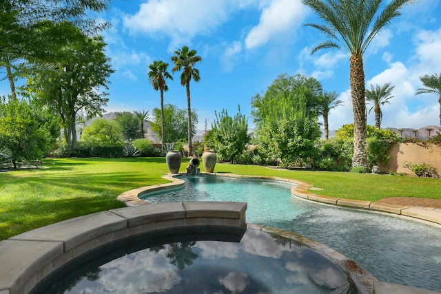 view of swimming pool with a yard and an in ground hot tub