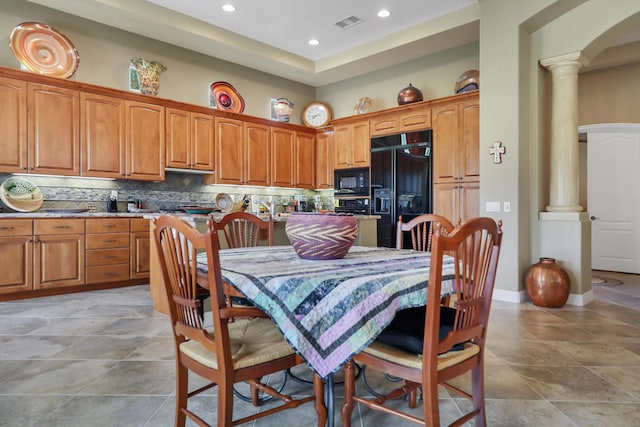 tiled dining area featuring decorative columns