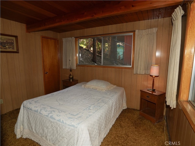 bedroom with carpet, wooden walls, and beamed ceiling