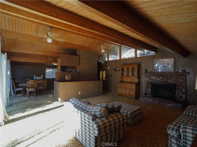 living room featuring lofted ceiling with beams, a fireplace, wood walls, wooden ceiling, and ceiling fan