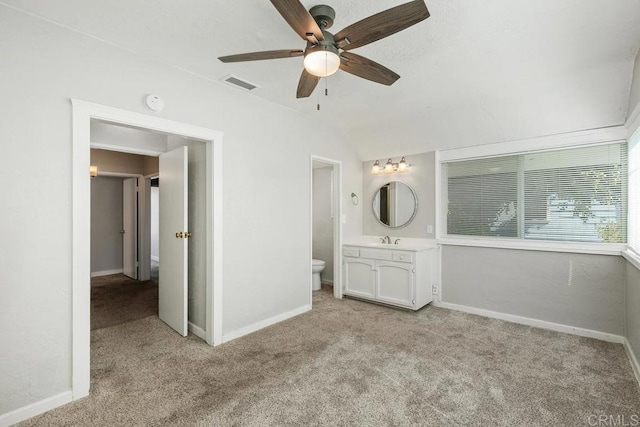 unfurnished bedroom featuring ceiling fan, light colored carpet, connected bathroom, and sink