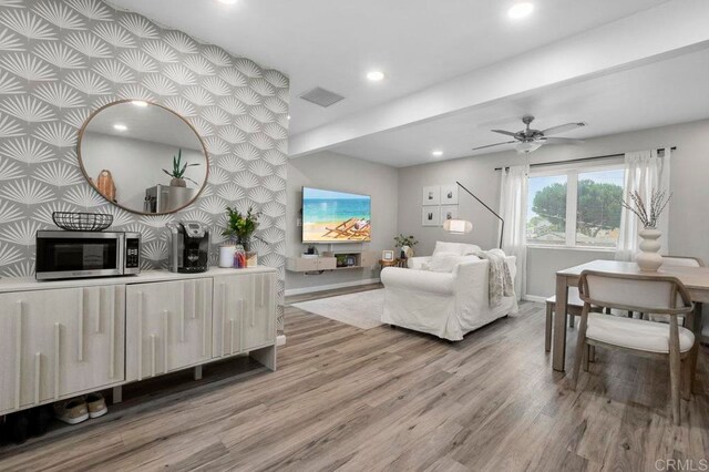 living room with wood-type flooring and ceiling fan