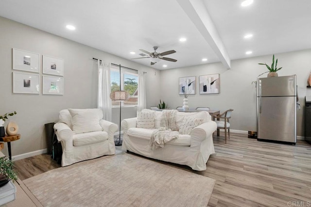 living room with light hardwood / wood-style flooring, beam ceiling, and ceiling fan