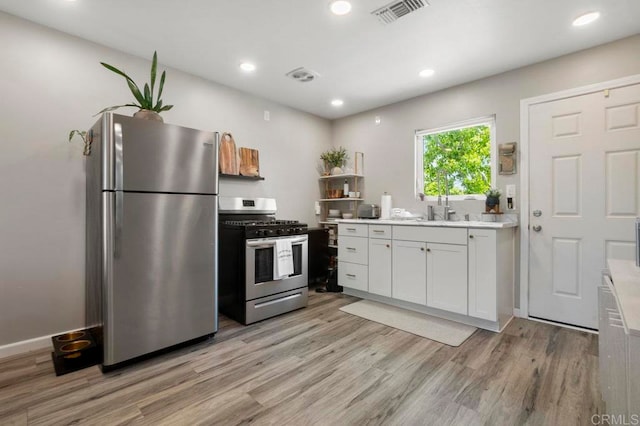 kitchen featuring light hardwood / wood-style flooring, white cabinetry, and appliances with stainless steel finishes