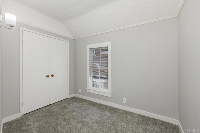 unfurnished bedroom with carpet, lofted ceiling, and a closet