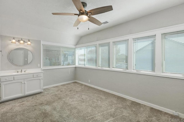 interior space featuring lofted ceiling, ceiling fan, and sink