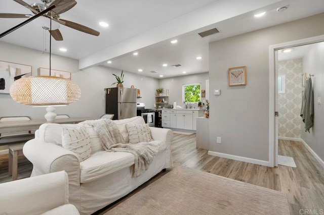 living room featuring ceiling fan and light wood-type flooring