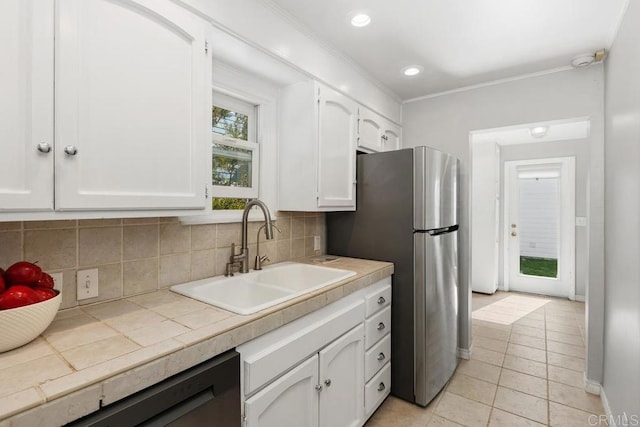 kitchen featuring light tile patterned floors, sink, white cabinetry, crown molding, and decorative backsplash