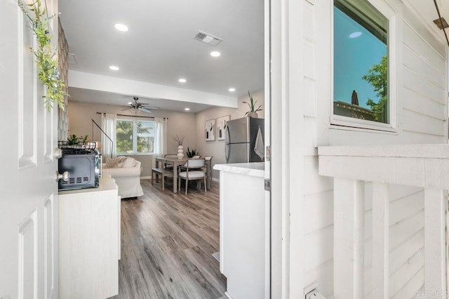 kitchen with stainless steel fridge, ceiling fan, and light hardwood / wood-style flooring