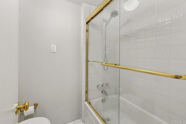 bathroom featuring shower / bath combination with glass door and toilet