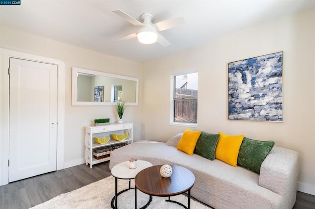 living room with ceiling fan and dark wood-type flooring