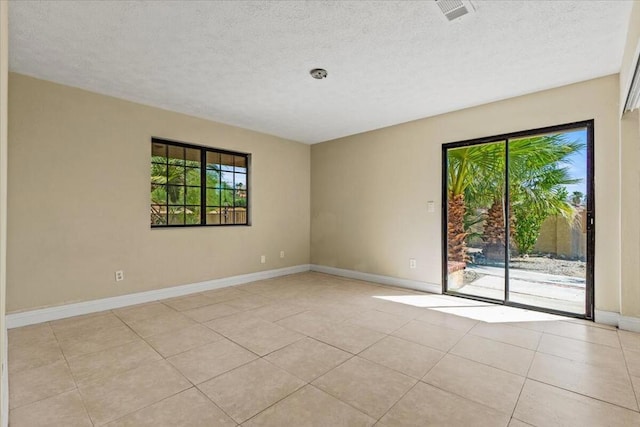 tiled spare room with a textured ceiling