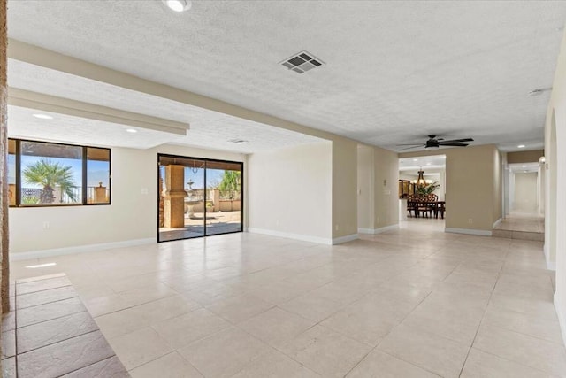 empty room featuring light tile patterned floors, ceiling fan with notable chandelier, and a textured ceiling