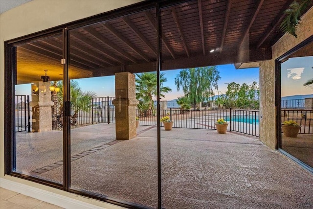 patio terrace at dusk featuring a fenced in pool