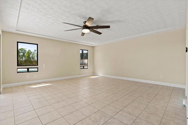 tiled empty room featuring a textured ceiling and ceiling fan