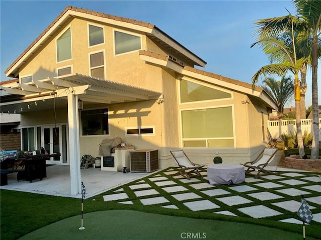 rear view of property with central AC unit, a pergola, and a patio