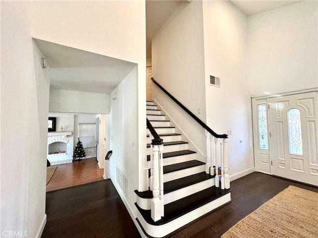 entryway featuring dark wood-type flooring and a fireplace