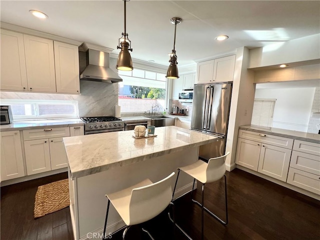 kitchen featuring light stone countertops, wall chimney exhaust hood, a breakfast bar area, and high end appliances