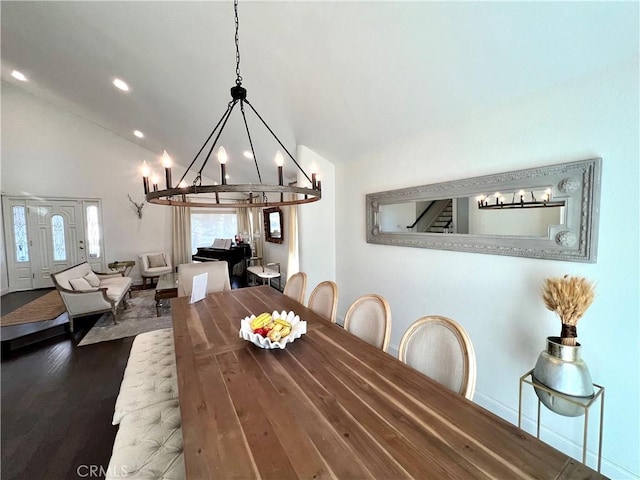 dining area featuring vaulted ceiling, dark wood-type flooring, and a chandelier