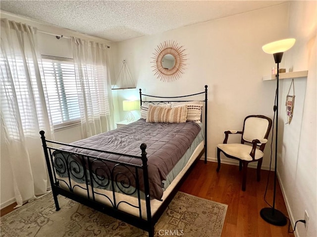 bedroom with dark hardwood / wood-style flooring and a textured ceiling