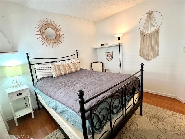 bedroom featuring dark hardwood / wood-style floors and a textured ceiling