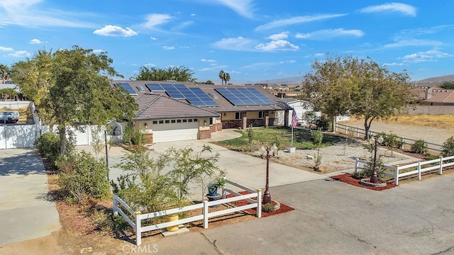 ranch-style house with a garage and solar panels