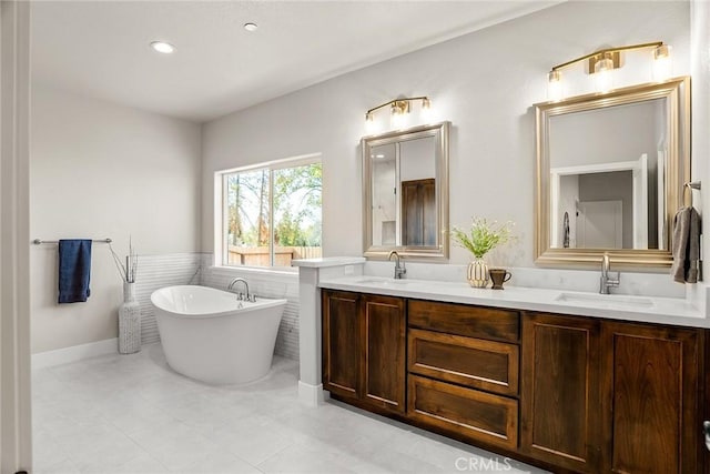 bathroom featuring a bathtub, tile walls, and vanity