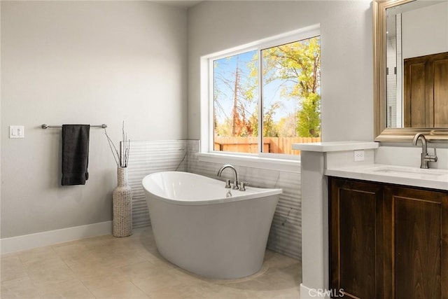 bathroom with tile patterned flooring, a bathtub, tile walls, and vanity