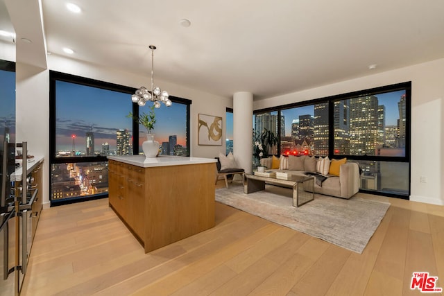 interior space with a center island, light hardwood / wood-style floors, decorative light fixtures, and a notable chandelier