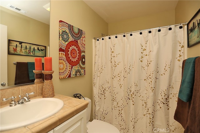 bathroom with vanity, decorative backsplash, a shower with curtain, and toilet