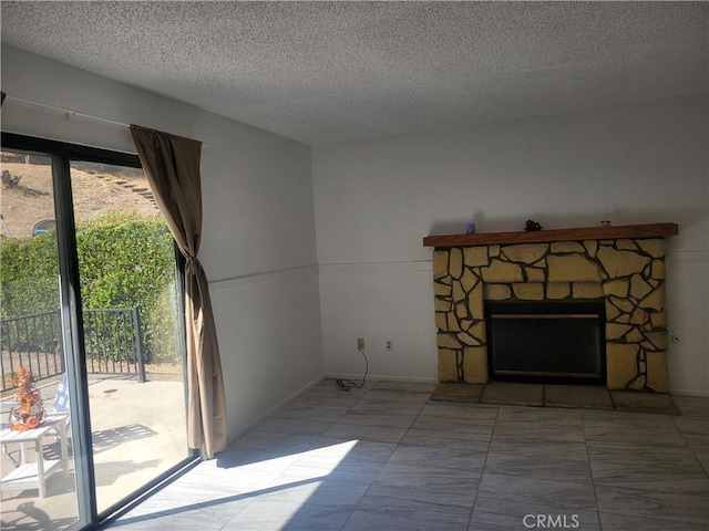 unfurnished living room with a stone fireplace, a healthy amount of sunlight, and a textured ceiling