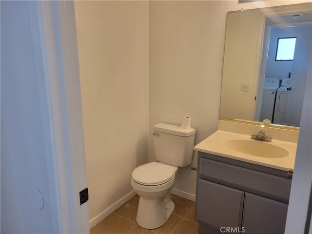 bathroom featuring tile patterned floors, washer and dryer, toilet, and vanity