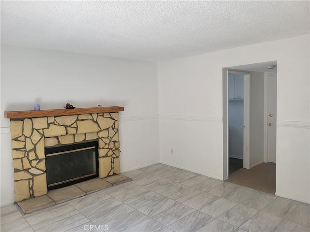 unfurnished living room with a textured ceiling and a stone fireplace